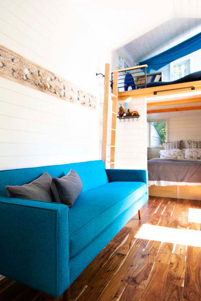 The teal blue Sterling custom sofa from Perch Furniture provides a comfortable place to lounge at the center of this tiny home