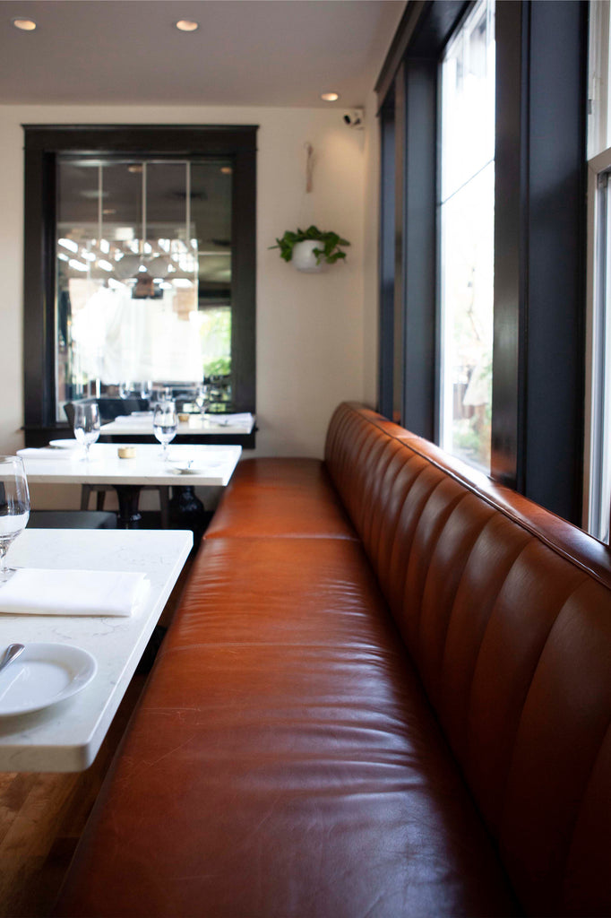 Comfy custom built leather banquettes circle the dining room of Ariana Restaurant in Bend, Oregon. 