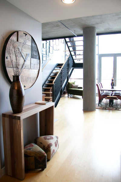 The loft like condo features an entry way with a custom wood console table
