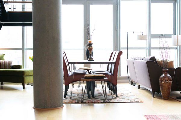 The dining area is defined by a large area rug and separated from the living area by a sectional.