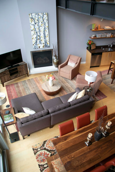 A sectional and strategically placed rugs help define a large, open format living area.