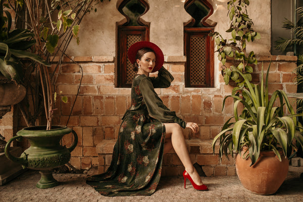 Influencer and Story Teller Aida Dapo Muharemovic sat down in our Verdant Maxi Wrap Dress styled with a wide brimmed red hat and matching red stiletto heels.