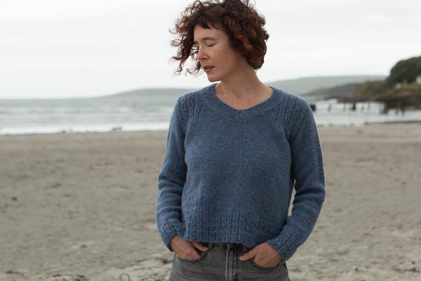 woman on beach wearing blue blasta knitted sweater