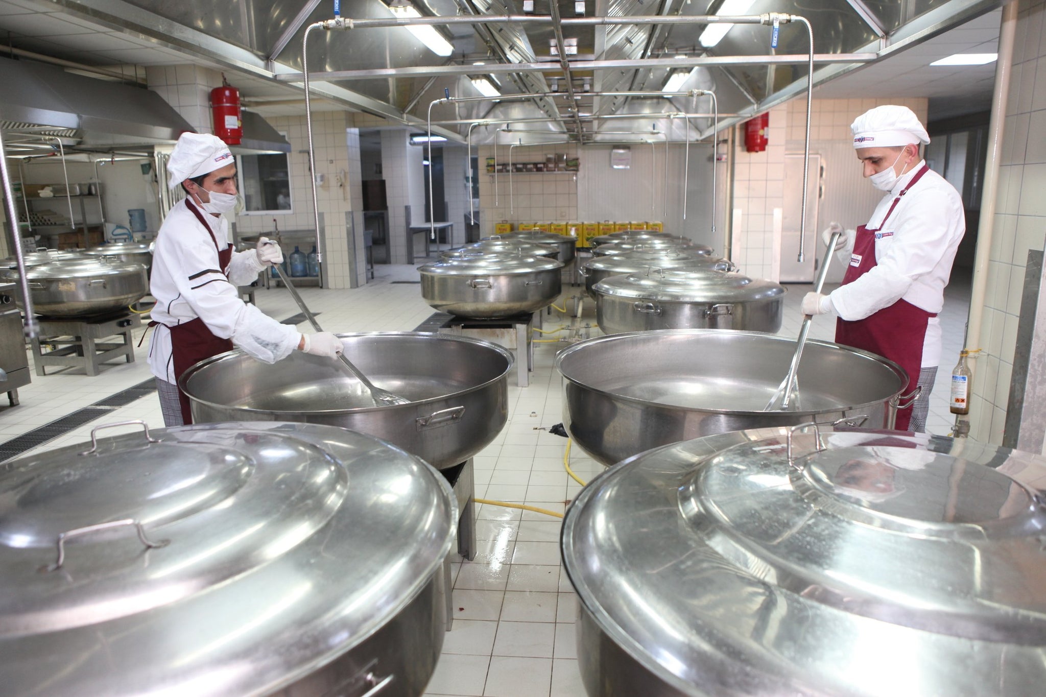 Workers mixing in a hydrocolloid to their food recipe.