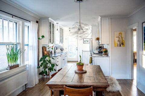 A scand-style dining room with a 31 bubble chandelier centered over a farmhouse table. 