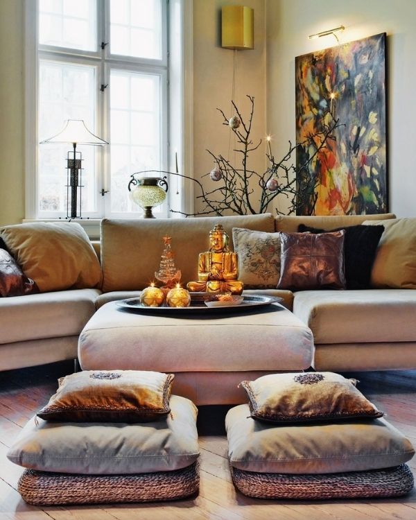 Eclectic meditation room with two sets of pillows to sit on on the ground and a couch
