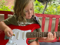 little girl playing the guitar