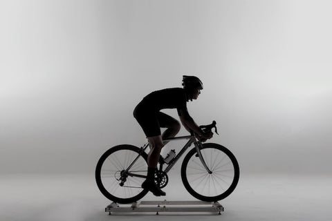 Black and white profile image of male on a bike trainer