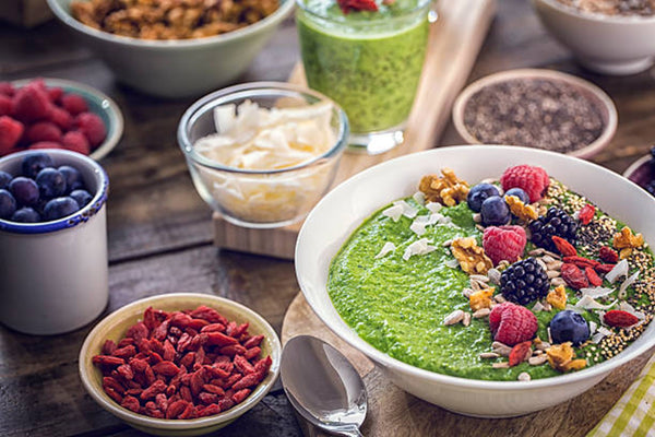 table full of healthy foods, green smoothies & superfoods