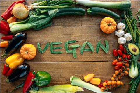 Veganes Logo, umgeben von Bio-Obst und -Gemüse