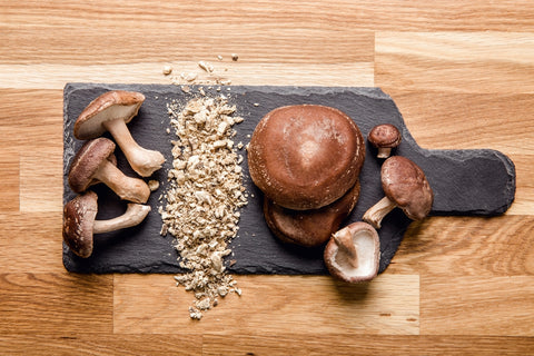 A variety of mushrooms and mushroom powders on a cutting board