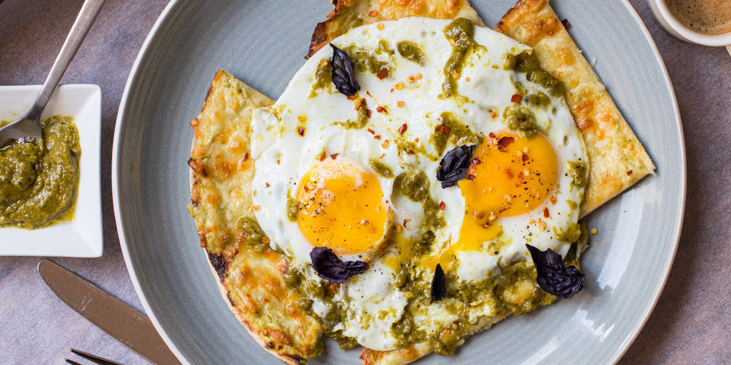 Pesto fried eggs on Lo-Dough cheesy toast on a grey plate