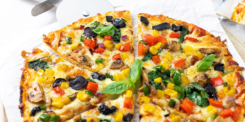 Low calorie Lo-Dough pizza with colourful mixed vegetables on wooden board