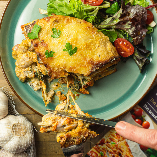 Keto Lo-Dough lasagne for one on a grey plate with a portion taken out of it