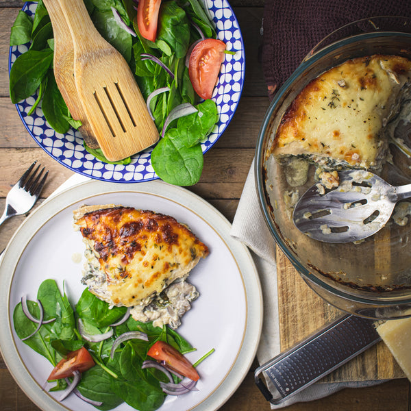 Healthy Lo-Dough lasagne on a wooden table with a salad and dish 