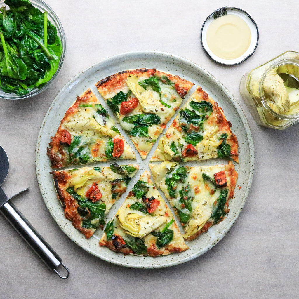 Low calorie gut health spinach and artichoke pizza on a plate 