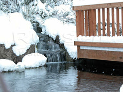 Waterfall and pond in winter with snow and ice
