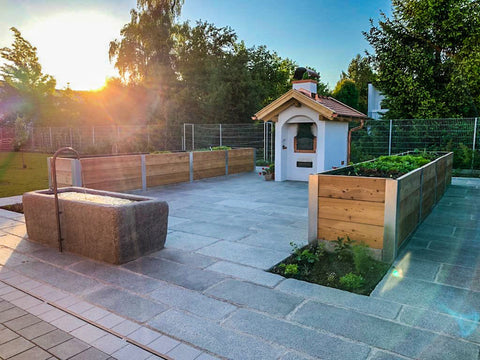 Neue graue Granitplatten kombiniert mit einem Gartenbrunnen