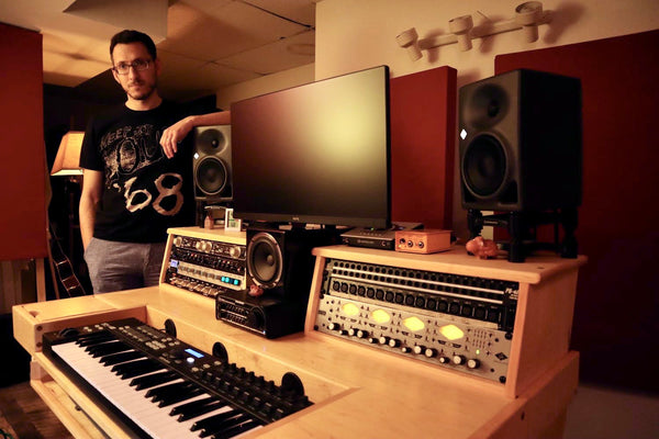 Vadim standing next to a music production desk