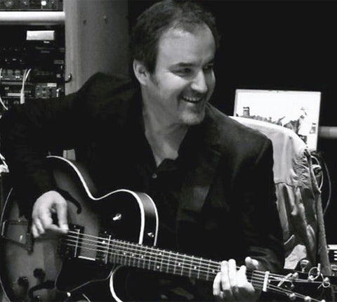 David Arnold playing a guitar