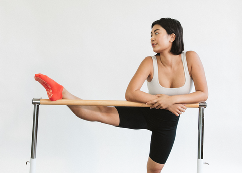 woman practicing barre on ballet bar