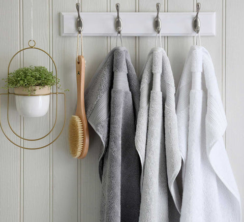 Egyptian cotton towels hanging from hooks on wall