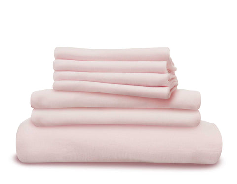 Pink linen duvet cover, fitted sheet and pillowcases in a pile