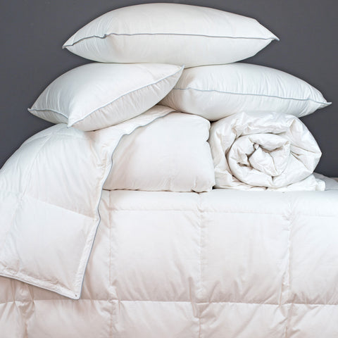 Pile of Goose Down Duvets and Pillows on a Bed | scooms