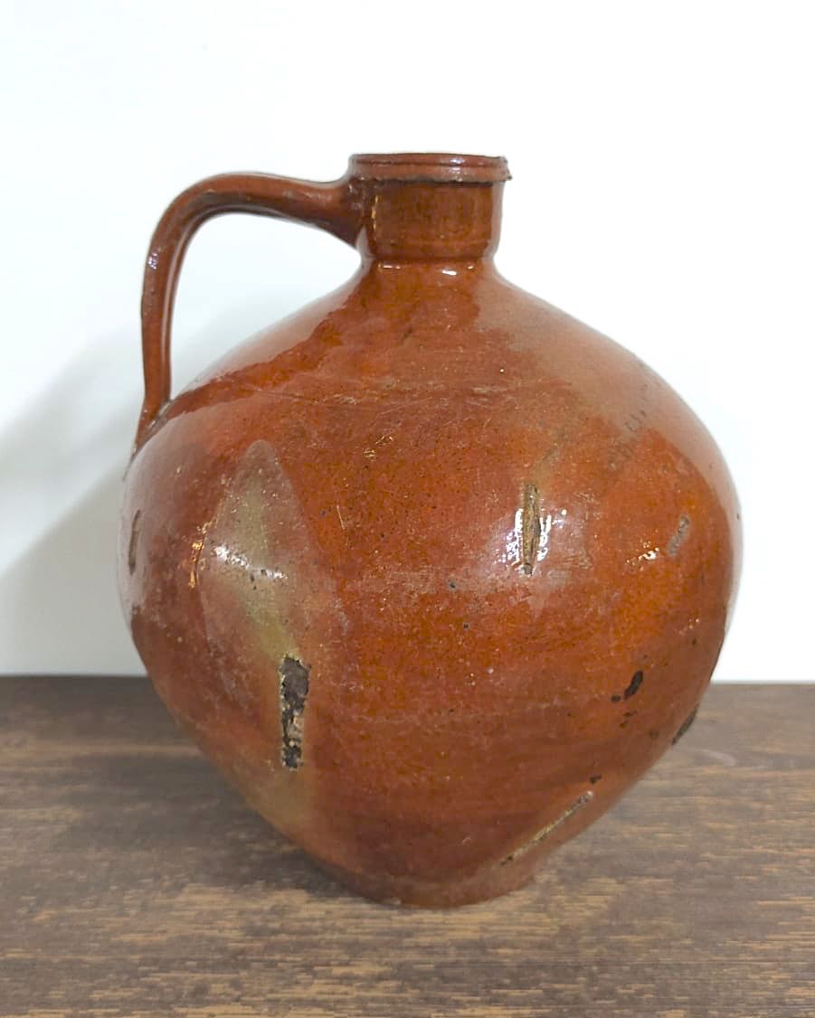 Antique round rust colored oil jar with handle