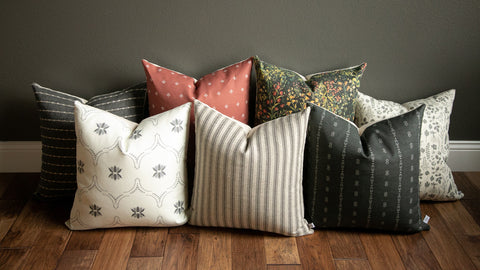 fall 2021 throw pillow combo shown in a rust pillow, floral pillow, black pillow, rich warm color palette
