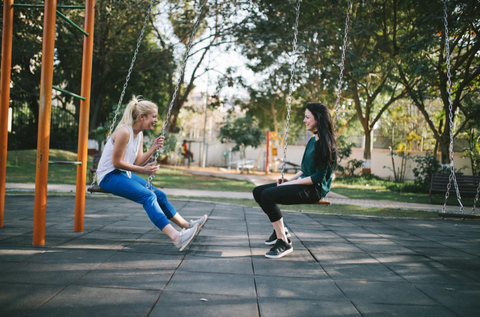 friends chatting on a swing