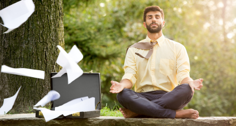 man sitting in meditation pose in work clothes