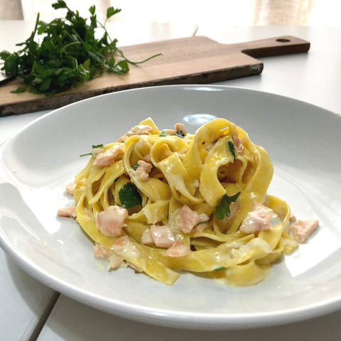 Creamy salmon tagliatelle with parsley in the background - pasta evangelists