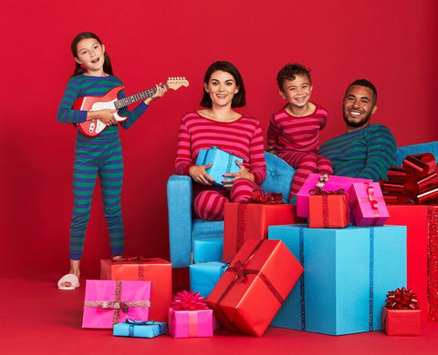 family in matching pajamas with holiday gifts