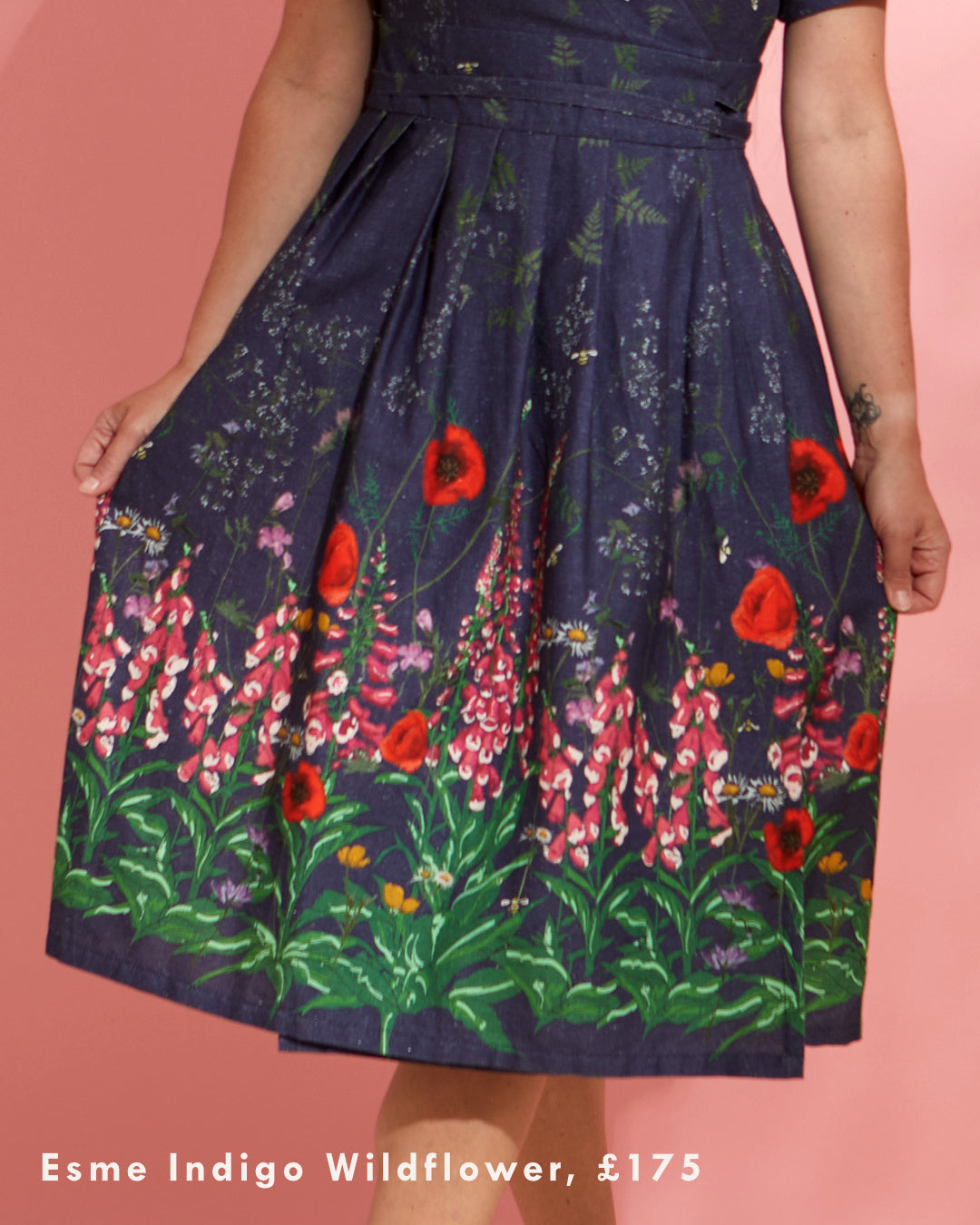 Close up of the border print of a dress. It depicts foxgloves, poppies and other flowers on an indigo blue background