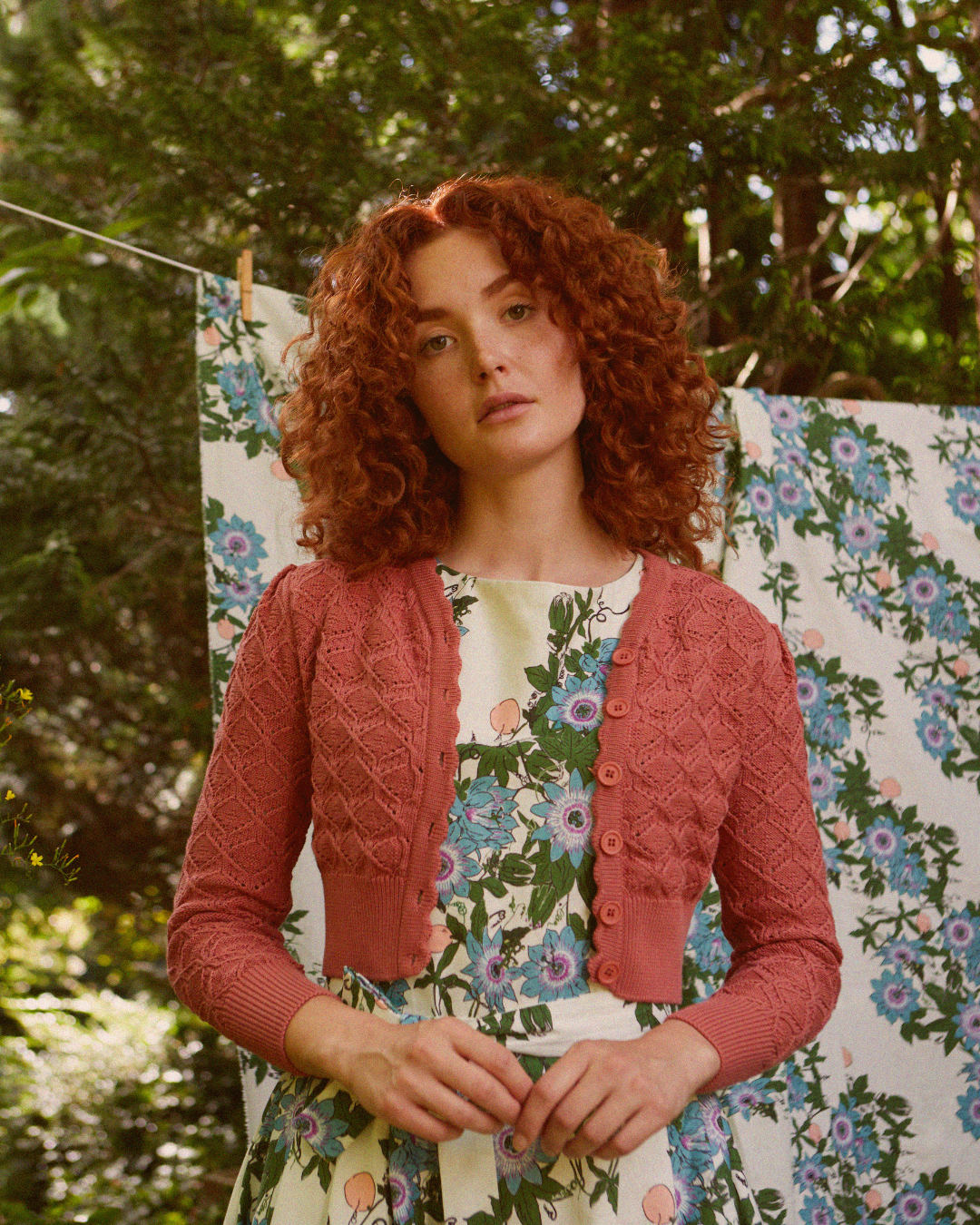 Woman wearing a white flower printed dress and a dark rose cardigan