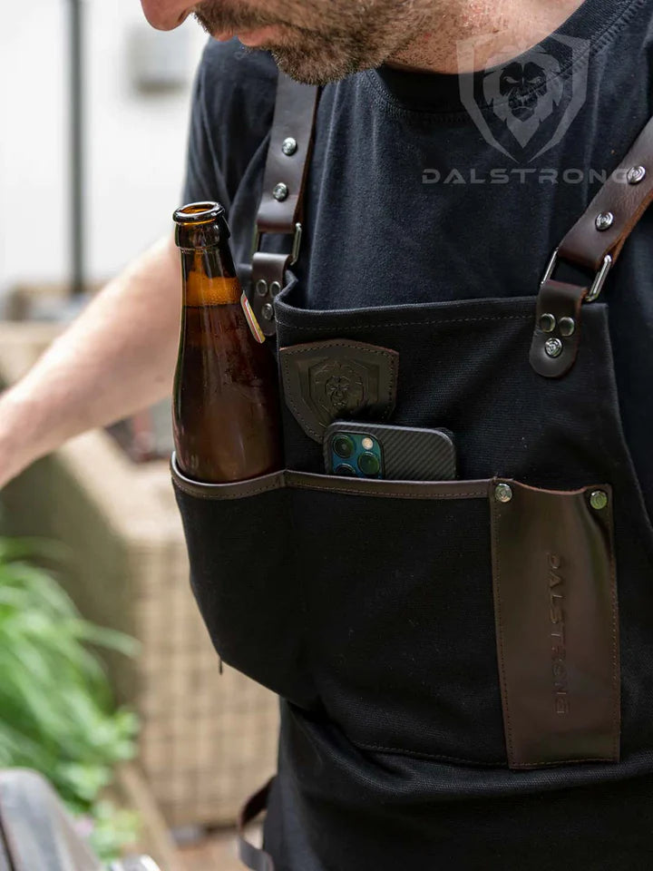 A man wearing the Heavy-Duty Waxed Canvas BBQ Apron with a beer and a phone in the pocket.