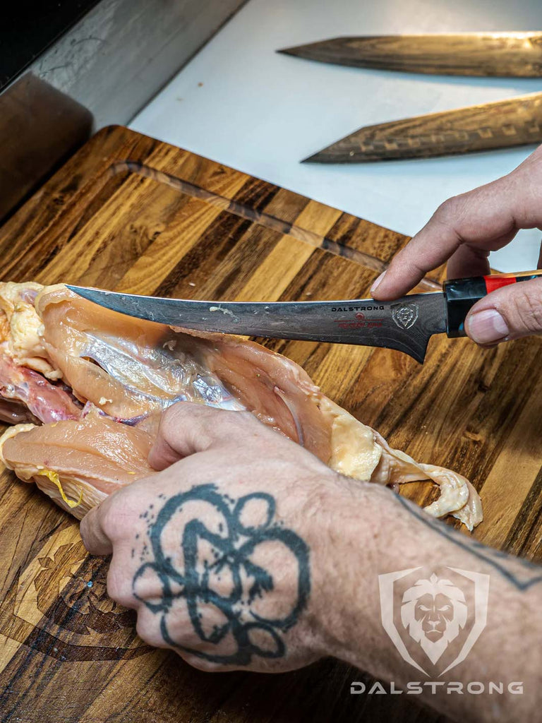 A photo of a mans hand deboning chicken using Curved Boning Knife 6" | Firestorm Alpha Series | Dalstrong