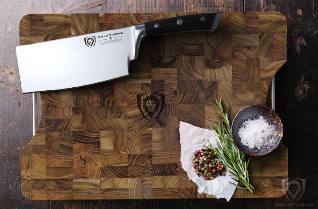 A photo of the Lionswood Colossal Teak Cutting Board Dalstrong with a Dalstrong cleaver knife on top of it.