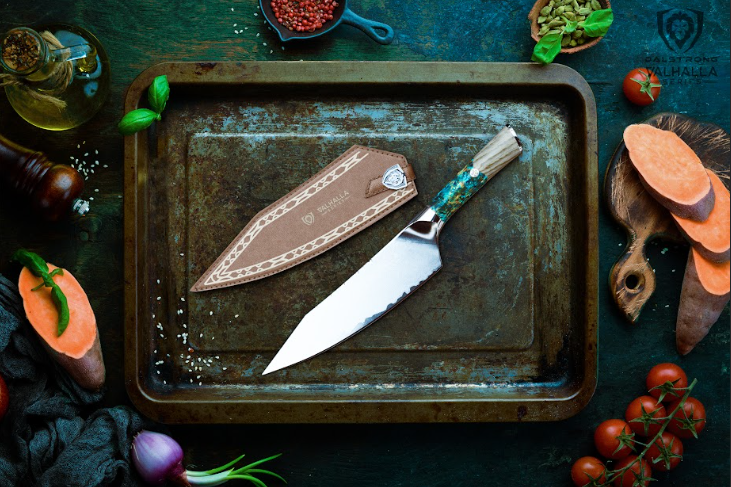 A photo of the Chef's Knife 8" Valhalla Series | Dalstrong with sheath beside it inside an old aluminum tray