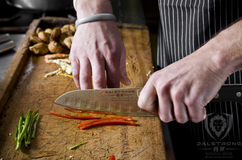 A photo of a hand slicing bell pepper using the Santoku Knife 7" Shogun Series ELITE | Dalstrong.