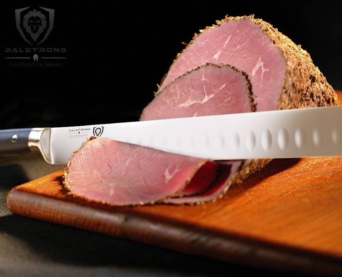 A photo of the Slicing & Carving Knife 12" Gladiator Series | NSF Certified | Dalstrong with a ham sliced in two pieces