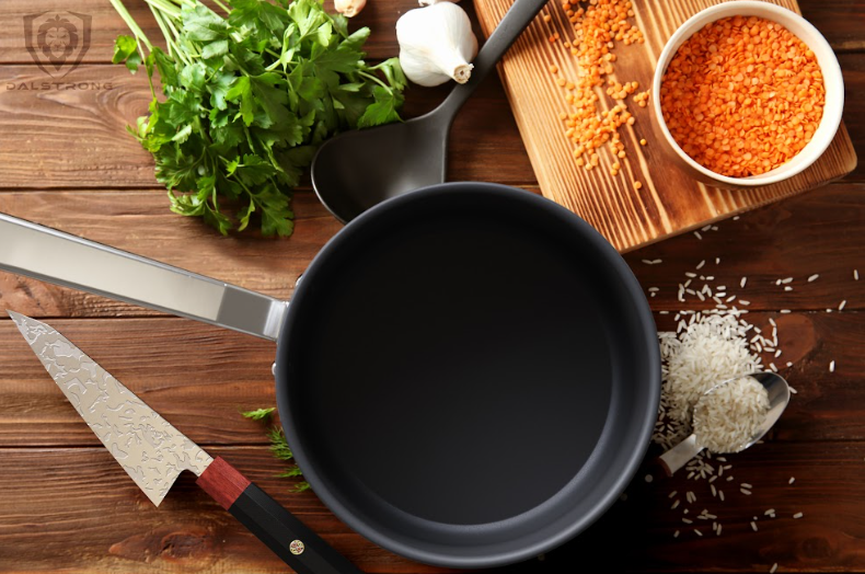 A photo of the 3 Quart Stock Pot ETERNA Non-Stick | Oberon Series | Dalstrong with a Dalstrong knife on top of a wooden table