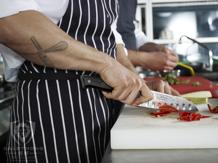 A photo of a man slicing red bell pepper using the Santoku Knife 7" Shogun Series ELITE | Dalstrong