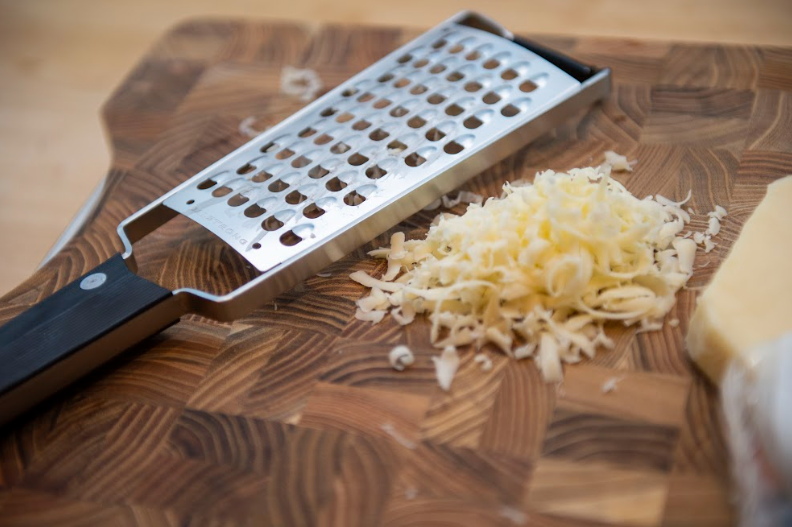 A photo of a grated cheese with the Professional Extra Coarse Wide Cheese Grater | Dalstrong