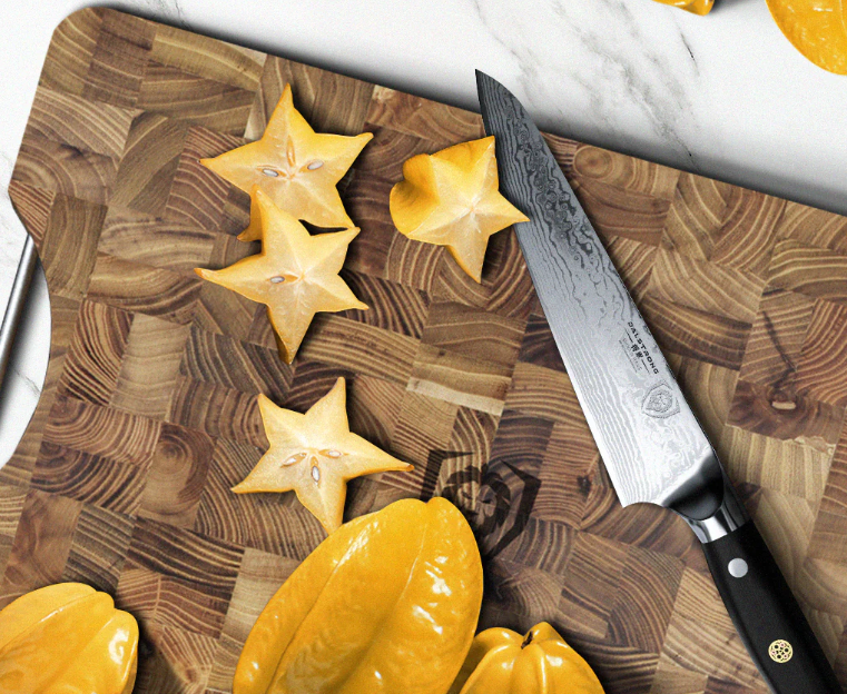 A photo of the Chef's Knife 7" Shogun Series ELITE | Dalstrong with slices of star fruits on top of a Dalstrong wooden board.