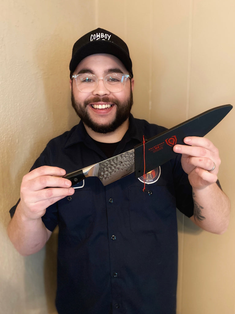 Jesse Stanley (@pitmasterpastor) holding a Dalstrong shogun chef knife