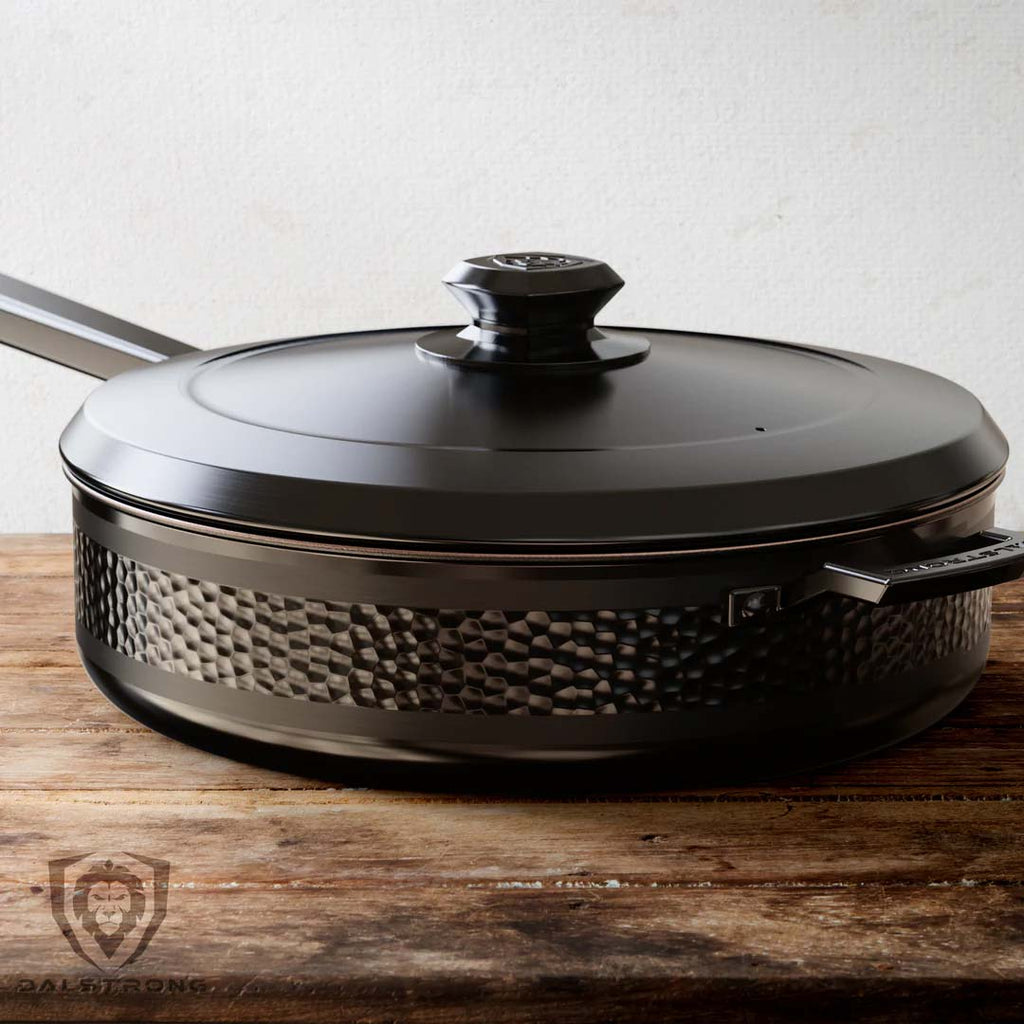 12" Sauté Frying Pan | Hammered Finish Black | Avalon Series | Dalstrong on top of a wooden table.