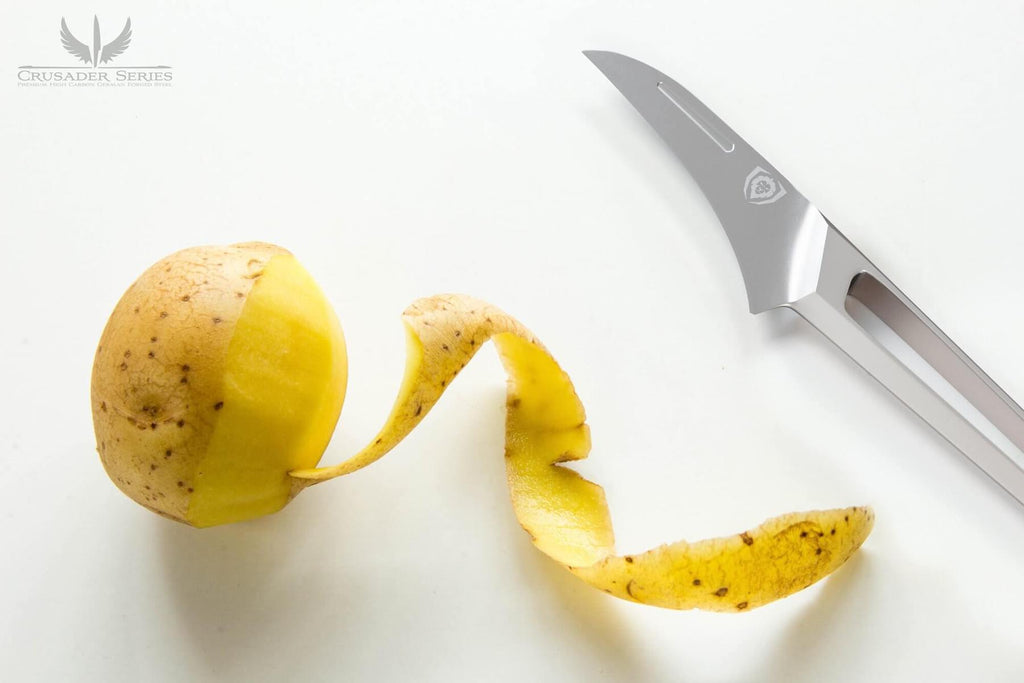 Peeled potato on a white surface next to a stainless steel paring knife with a hollow handle