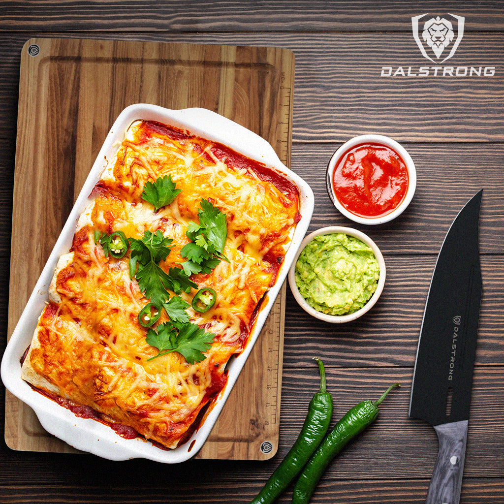 Chicken enchilada on a white tray with a Dalstrong cutting board underneath and Dalstrong Delta Wolf Chef Knife, chilis, and dips on the side.